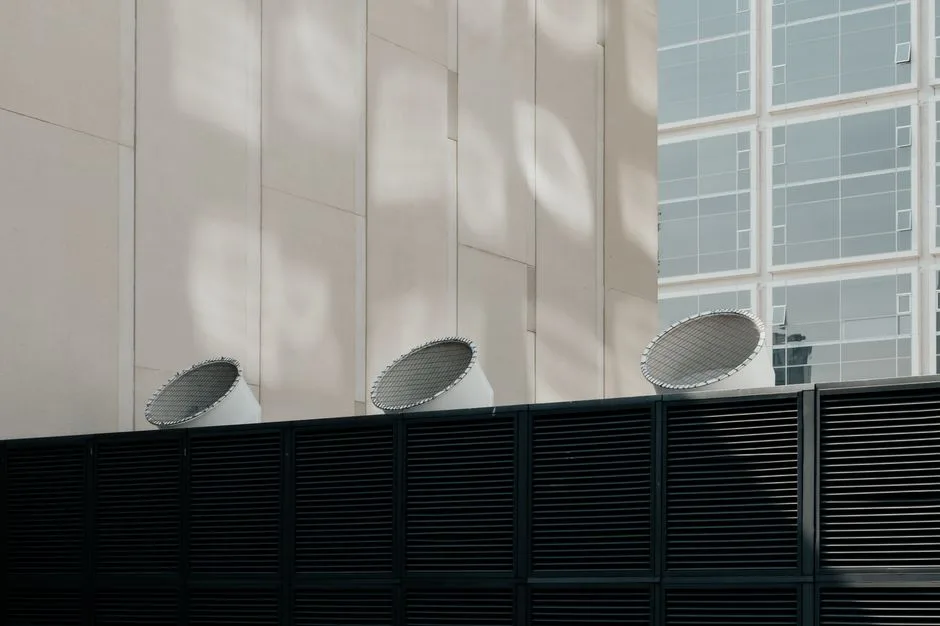 Low-angle view of industrial ventilation pipes and exhaust fans on a commercial rooftop above a Hammonton restaurant